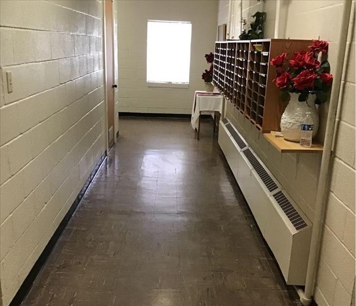 White hallway fully cleaned and dried concrete floors after flood damage. 