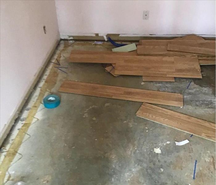 Floor in home with subfloor showing and planks of wooden floor ripped up