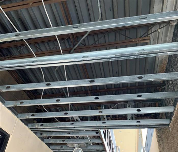 Metal rafters and metal ceiling exposed after drywall removal.