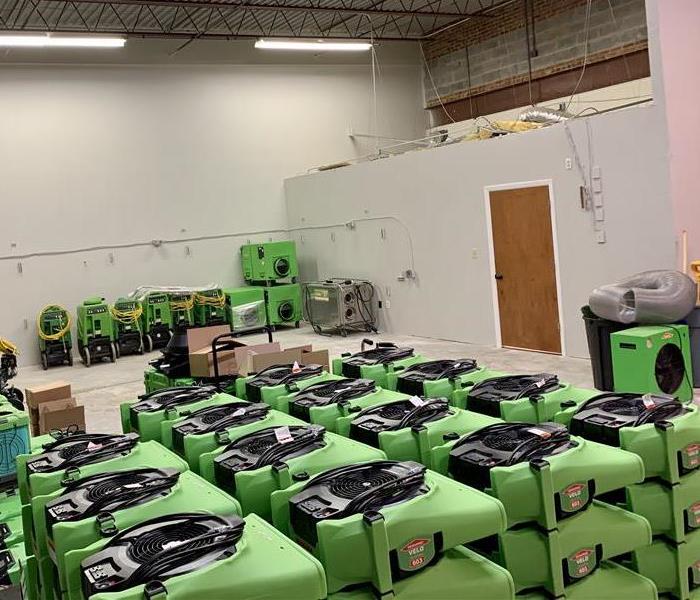 warehouse with green air movers stacked up on each other in multiple rows