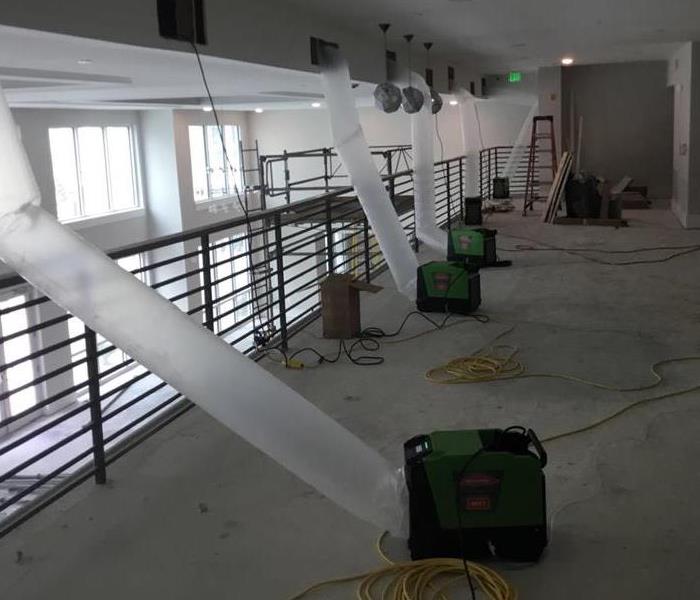 Green air movers vented into cut outs in a wet ceiling to dry water