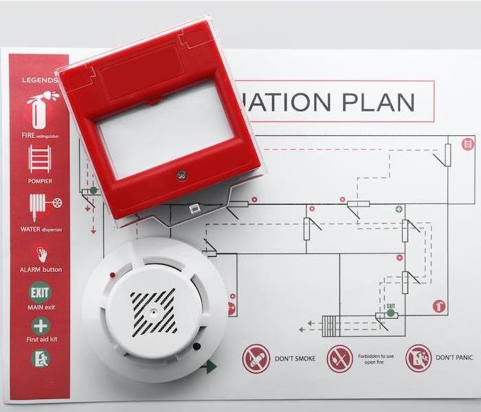 a fire alarm and evacuation plan sitting on a grey table